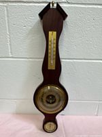 Full view of wooden wall weather station showing overall shape and three instruments