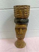 Front view of carved wood African female bust candle holder