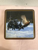 Lid view showing Phillip Crowe artwork and gold border