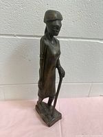 Full view front/side of wooden woman figurine on base