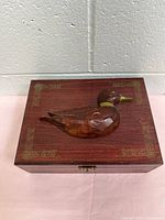 Closed box showing carved duck and decorative corners