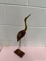 Full view of wooden and brass crane figurine on base