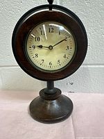 Front view of wooden table clock showing dial and bezel