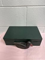 Closed tea box front view showing carved duck and green paint