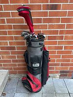 Full view of left-handed golf bag with clubs, including head covers and visible irons.