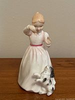 Front view of the Royal Doulton Reward figurine showing the girl feeding the dog in detail with clear colors and condition visible