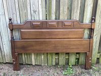 Front view of vintage solid wood double headboard showing decorative paneling, turned posts with finial tops, and Spanish Brown finish.