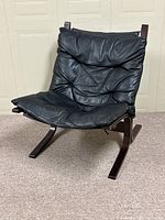 Front-right angle view showing padded leather seat and bent plywood frame