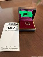Photo of the small 10k gold children's ring displayed in a purple velvet box with the green tape '10k' on the box lid
