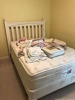 Full view of white bed frame, mattress, and box spring