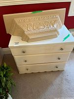 Cream dresser with three drawers and round knob handles, showing wear
