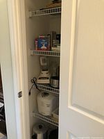 Shelf with Sunbeam blender, Crock Pot, Black & Decker bread maker, coffee urn, and some books or boxes