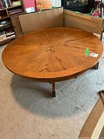 Full view of round oak pedestal table showing wood grain and overall condition.