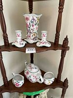 Teapot, creamer, sugar bowl, displayed on lower shelf showing floral Chinese Rose pattern