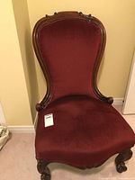 Front view of the Victorian accent chair showing upholstery and carved wood frame