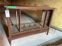 Side view of vintage wooden stereo cabinet showing hollowed out interior and worn condition.