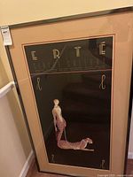 Full view of the framed Erté print in black frame with beige matting showing woman with leopard.