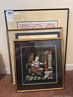 All five framed artwork pieces stacked against wall, showing varying sizes and frame styles.