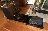 Two KEF speakers, Yamaha receiver, Luxman CD player and Sony CD clock radio arranged on floor