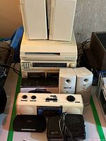 Full view of Yorx stereo set main unit with cassette player and two white speakers, plus smaller white stereo speakers and black portable stereo units in front