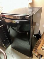 Black Danby mini fridge front view showing logo and door.