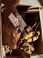 Box of assorted wooden decorative items including carved bust, trays, figurines, napkin holders.