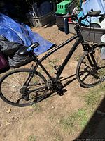 Full side view of the black Nakamura adult bicycle showing the frame, tires, and handlebars.