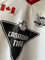 Close-up of Canadian Tire logo and maple leaf on jersey fabric
