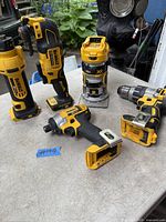 Five DeWalt cordless tools including two oscillating multi-tools, compact router, drill/driver and impact driver