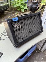 Front three-quarter view showing metal grille and dual speakers