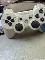 Angel view of the white Sony PS3 DualShock 3 wireless controller showing directional pad, analog sticks, and main face buttons.