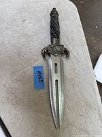 Top view of the dagger showing the full blade and handle with detailed guard and emblem.