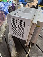 Side view of TOSOT window air conditioner showing ventilation grilles and power cord.