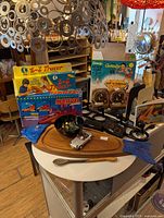 Overview of all items including vintage games, serving tray, toy car, bookends, and candle holders on table