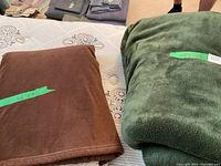 Brown fleece throw and green plush blanket on bed