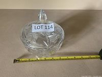 Side view of cut crystal lidded bowl with tape measure for scale