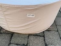 Beige fabric cover over round fire pit on patio