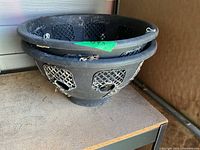 Two nested black plastic hanging baskets