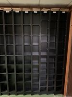 Front view of seven tall black IKEA Gnedby media towers showing adjustable shelves