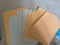 Stack of manila, grey and light-blue envelopes