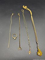 Five jewelry pieces arranged on black background