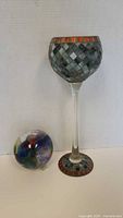 Shows the hand blown art glass ball beside the tall glass candle holder with mosaic design on cup and base.