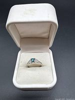 Ring in white jewelry box, front angle