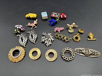 Overview of all 20 brooches showing various designs from novelty items to floral and geometric styles.