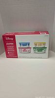 Box front showing set of 4 Disney Pyrex glass bowls with colorful character-themed prints and phrases