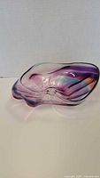 Side and top view of the purple, pink, blue, clear hand-blown art glass bowl showing its curvaceous freeform shape and colors.