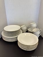 Full set of Mikasa dishes arranged showing dinner plates, bowls, side plates, cups, and saucers stacked.