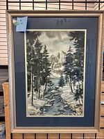 Full view of framed watercolor landscape painting showing snowy mountain, pine trees, creek, and signature.