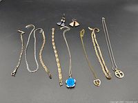 Top-down view of all necklaces and earrings spread out on black background