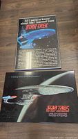 Two Star Trek posters side by side on floor, one with text about life lessons, another with Star Trek Enterprise-D image